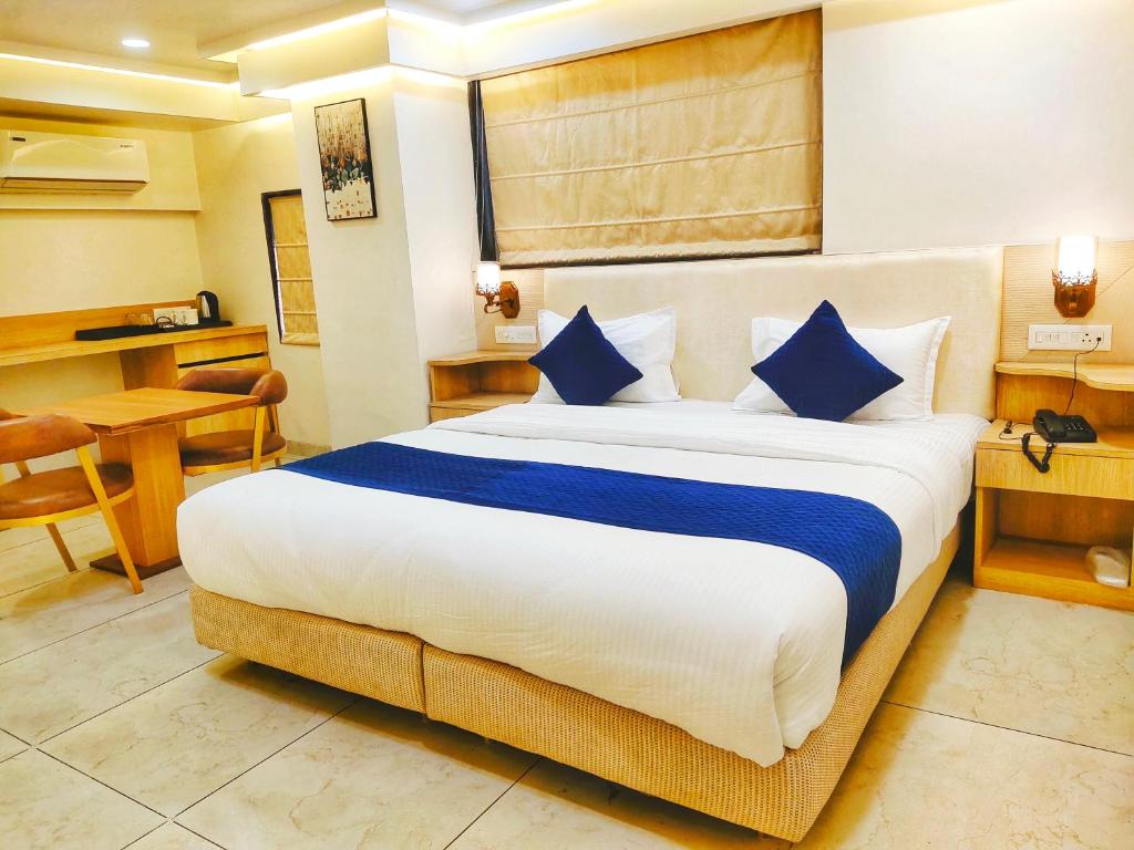a hotel room with a large bed with blue pillows at All seasons boutique rooms in Pune