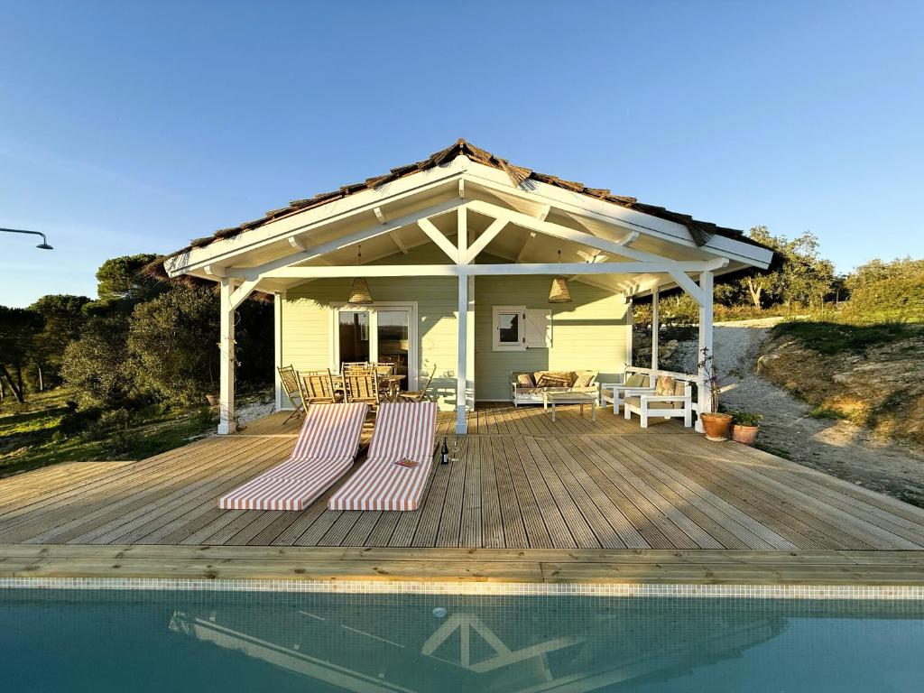 a covered deck with chairs and a swimming pool at Cabana in Sesimbra