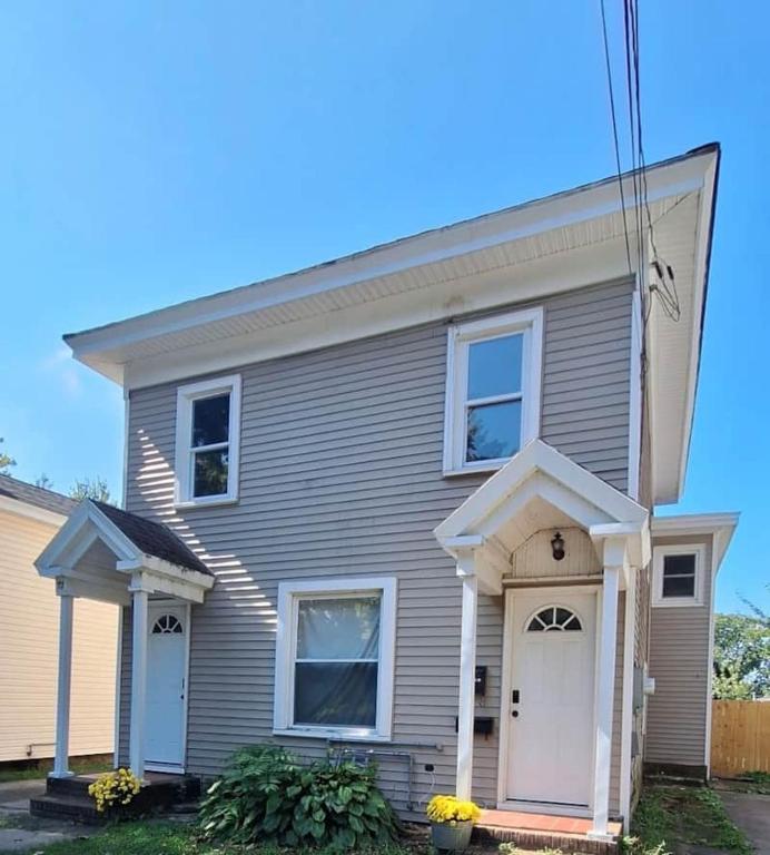 a gray house with white doors at Oswego 2BR Ground-Floor Apt Near SUNY, Walk to Downtown & Lake Ontario in Oswego