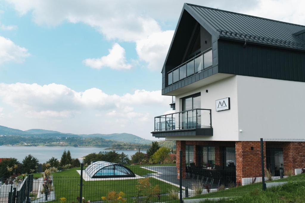 a house with a view of the water at VILLA nad JEZIOREM in Mucharz