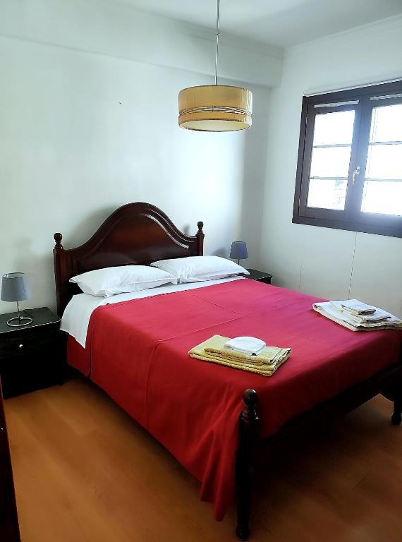 a bedroom with a large bed with a red blanket at Casa da Avó Maria in Podence
