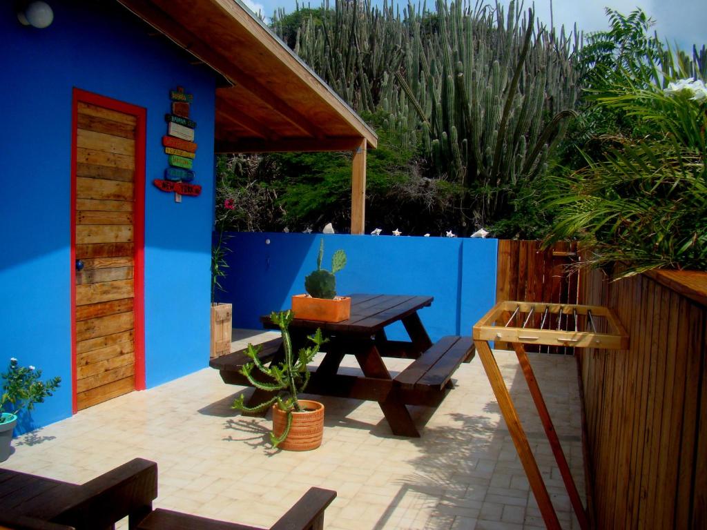 a patio with a picnic table and a blue wall at Hopi Cadushi Apartment in Santa Cruz