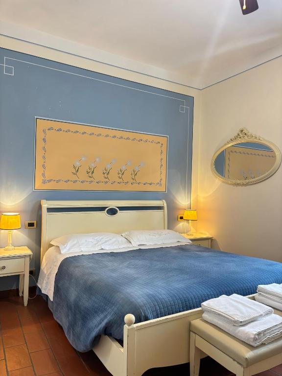a bedroom with a large bed with a blue headboard at Locanda Fuoriporta in Cantagrillo