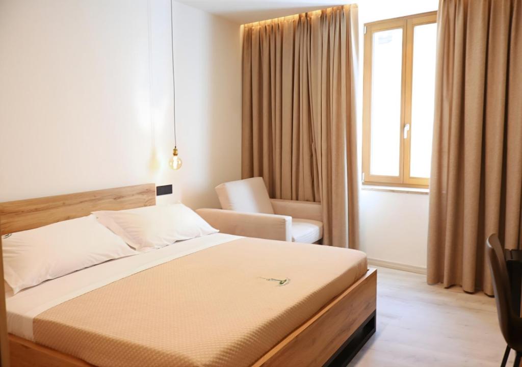 a bedroom with a bed and a chair and a window at Tower Suite Trento in Trento