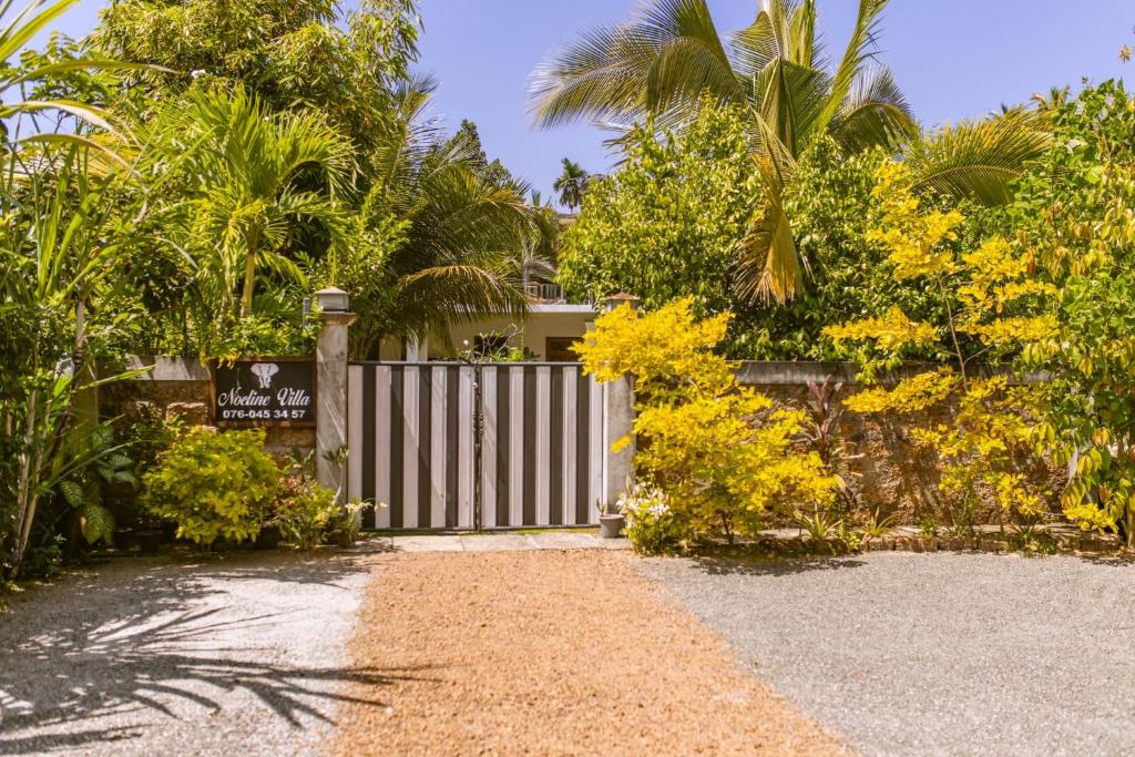 a gate in front of a house with trees at Noeline Villa in Bentota