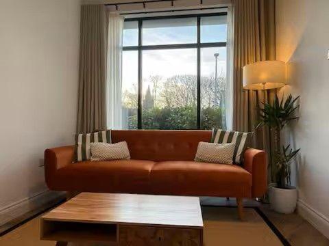 a living room with a couch in front of a window at Old Library Apartments - 8a in Orkney
