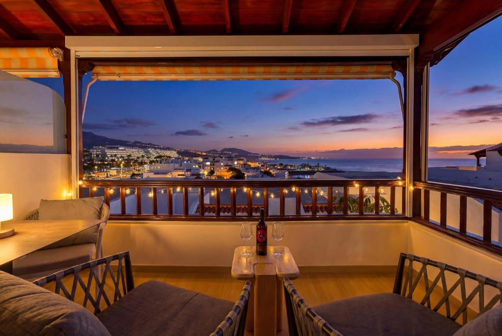 a balcony with a view of the city at night at Seaview Oasis Luxury Duplex La Caleta in Adeje