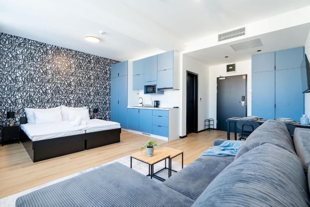 a living room with a couch and a kitchen at Azure Apartman Miskolc in Miskolc