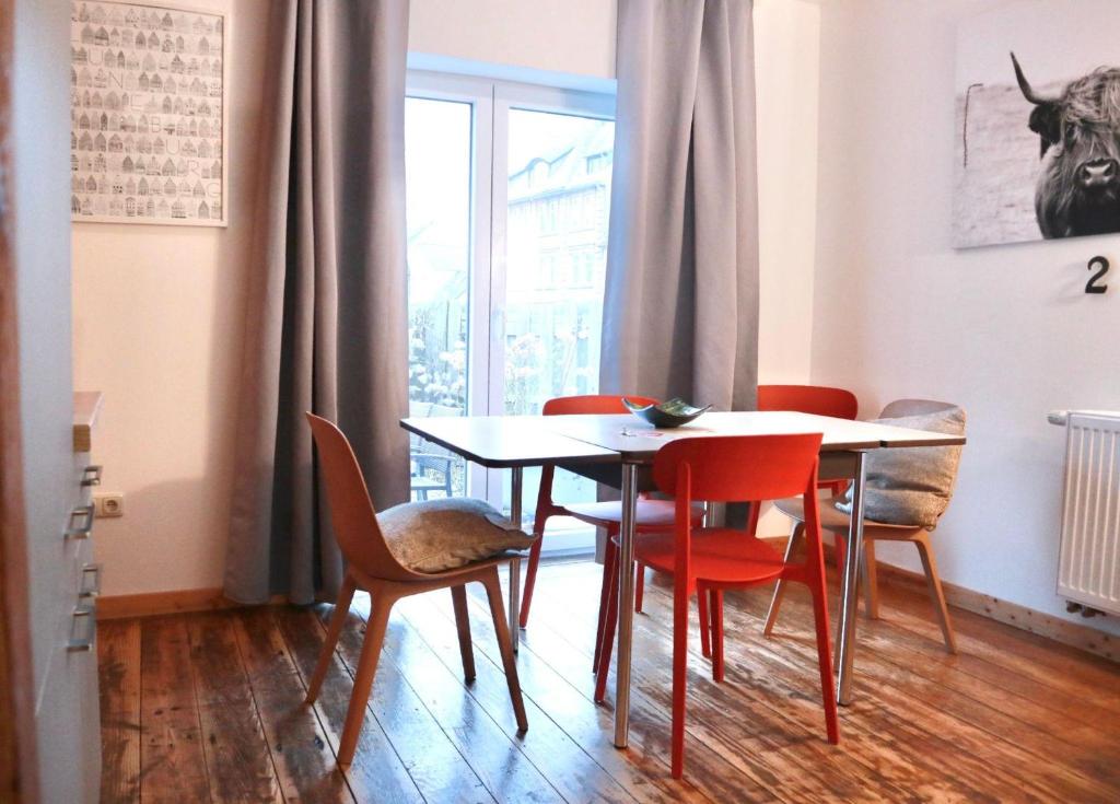 a dining room with a table and chairs and a window at Haus-Selma in Lüneburg