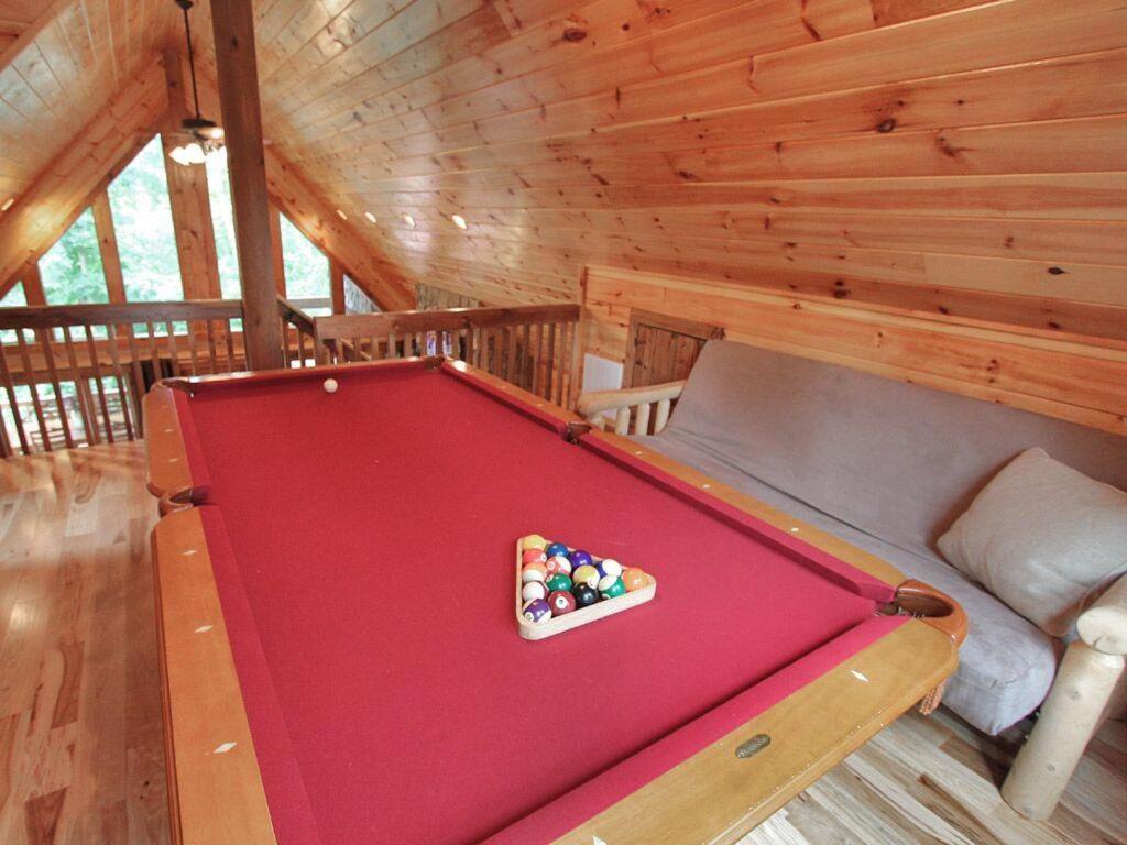 a red pool table in a wooden room with at Smoky Elk in Whittier