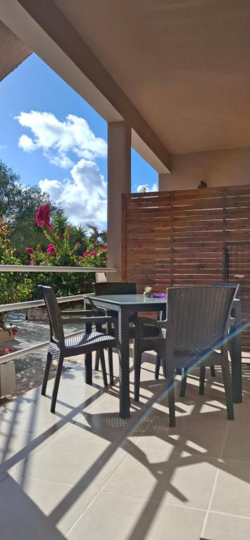 a patio with a table and chairs on a patio at Trousas Double Apartment in Roda
