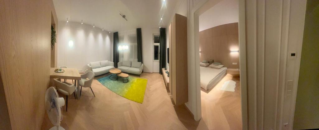 a living room with a bed and a room with a table at Im Grünen in Katzbach