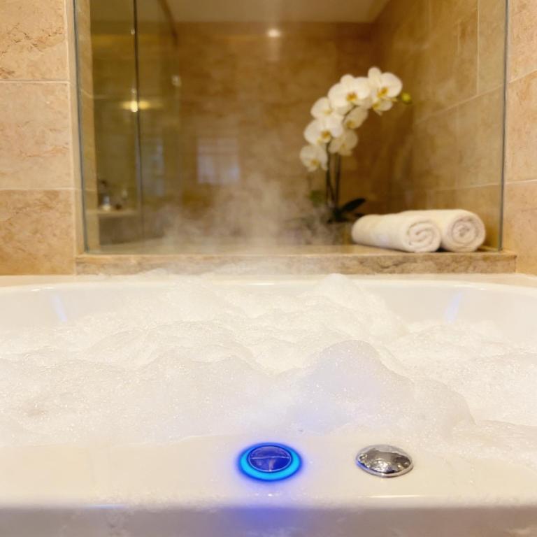 a bath tub filled with boiling water in a bathroom at Cozy spa sun set in Trois Bassins