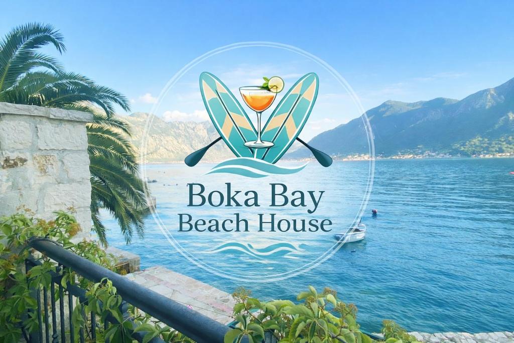 a sign for a beach house next to the water at Boka Bay Beach House in Dražin Vrt