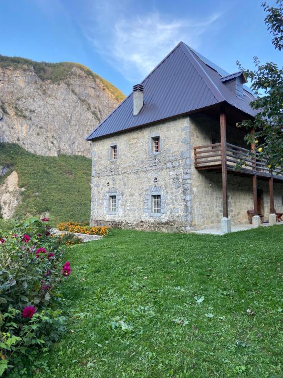 a large stone building with a black roof at Guest House Prebibaj in Curraj i Epërm