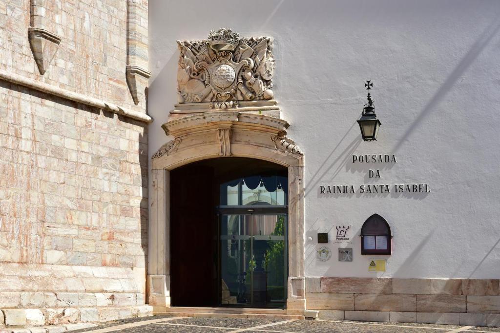 un accès à un bâtiment doté d'une horloge dans l'établissement Pousada Castelo de Estremoz, à Estremoz