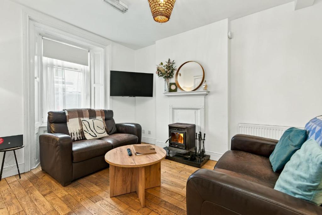 a living room with two couches and a wood stove at Wolfe Tone Apartment in Sligo