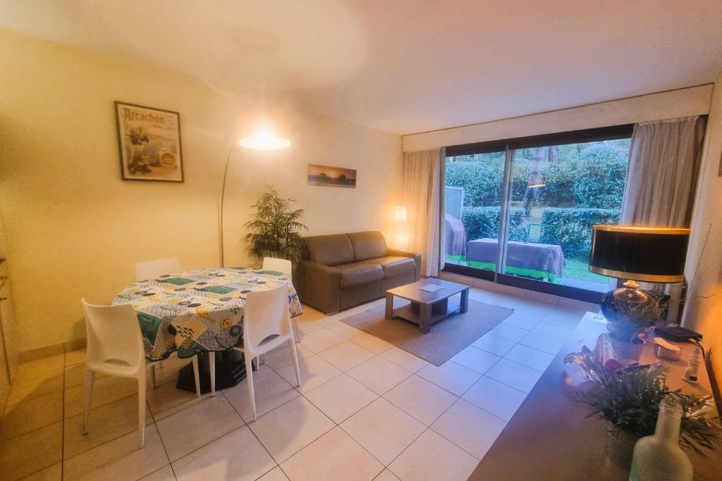 a living room with a table and a couch at 100 m from the beach prime location in Arcachon