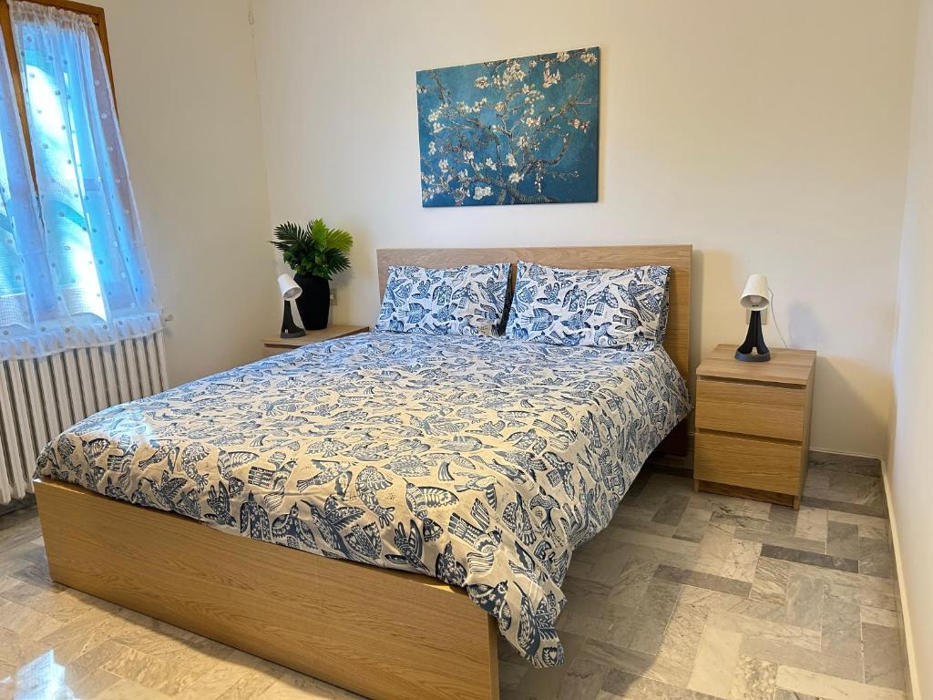 a bedroom with a bed and a painting on the wall at Discovering Apartment Pulicchio in Abetone