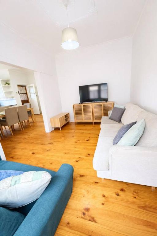 a living room with two white couches and a television at 2BR Beachfront Escape in Largs North in Semaphore