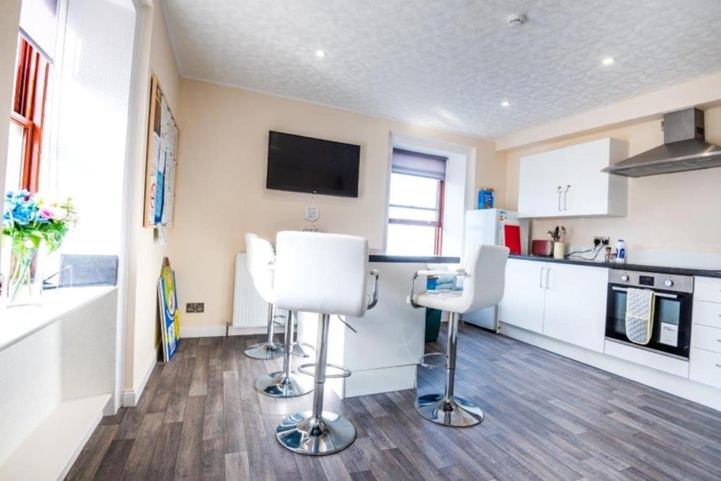 a kitchen with two white chairs and a counter at Josies House - Bright & Cozy Stay in Banff