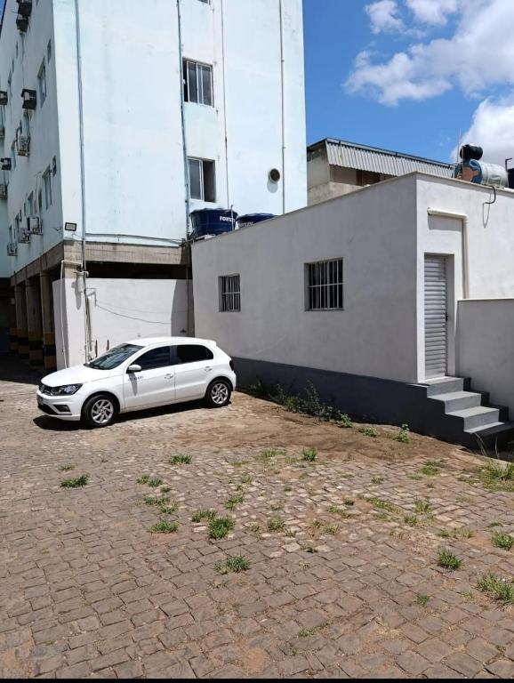 a white car parked in front of a building at Apart hotel in Três Marias