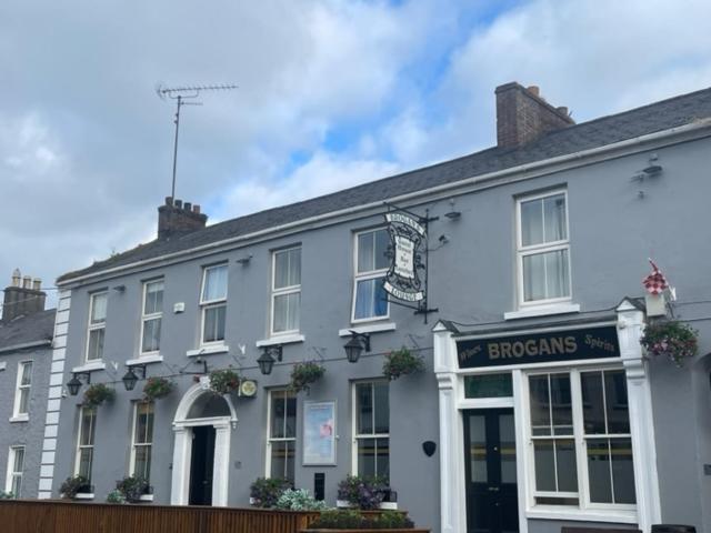 a white building with a sign in front of it at Brogans Bar & Hotel in Trim