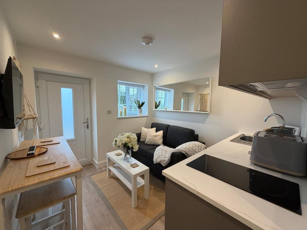 a kitchen and a living room with a couch at Rosewell Lower Dicker in Horsebridge