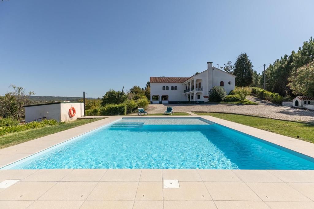 a swimming pool in front of a house at Quinta Vale Leitão in Coimbra