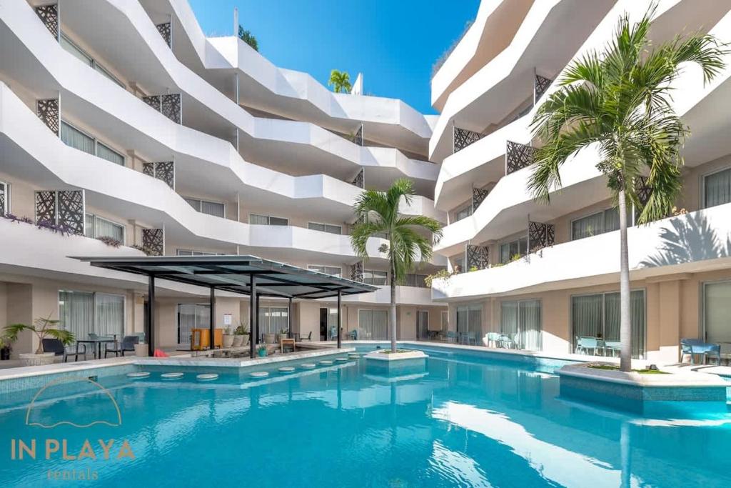 an exterior view of a building with a swimming pool at Steps from 5th Ave with Rooftop Pool Gym & Cinema in Playa del Carmen