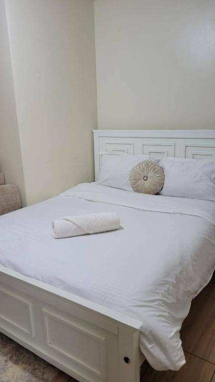 a white bed with two white towels on it at Krystal suites in Juja