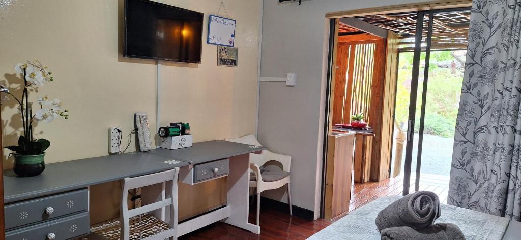 a room with a desk with a tv on the wall at Mitat Guesthouse in Beaufort West