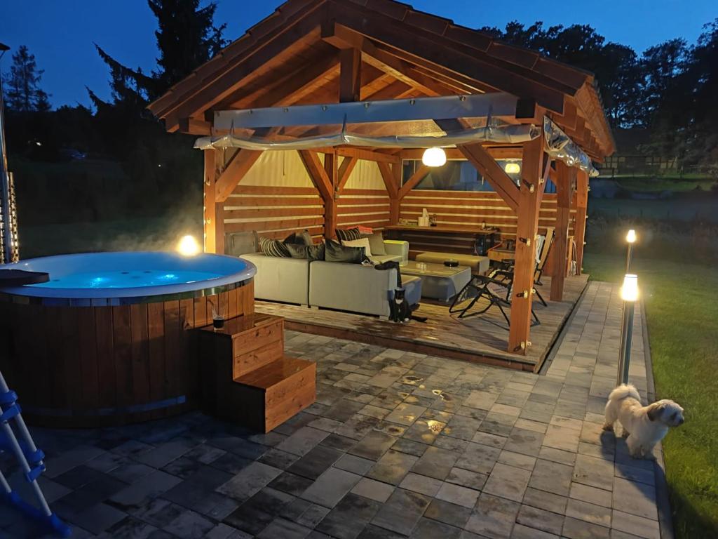 a wooden pavilion with a hot tub in a backyard at POD DĘBEM in Cerkiewnik