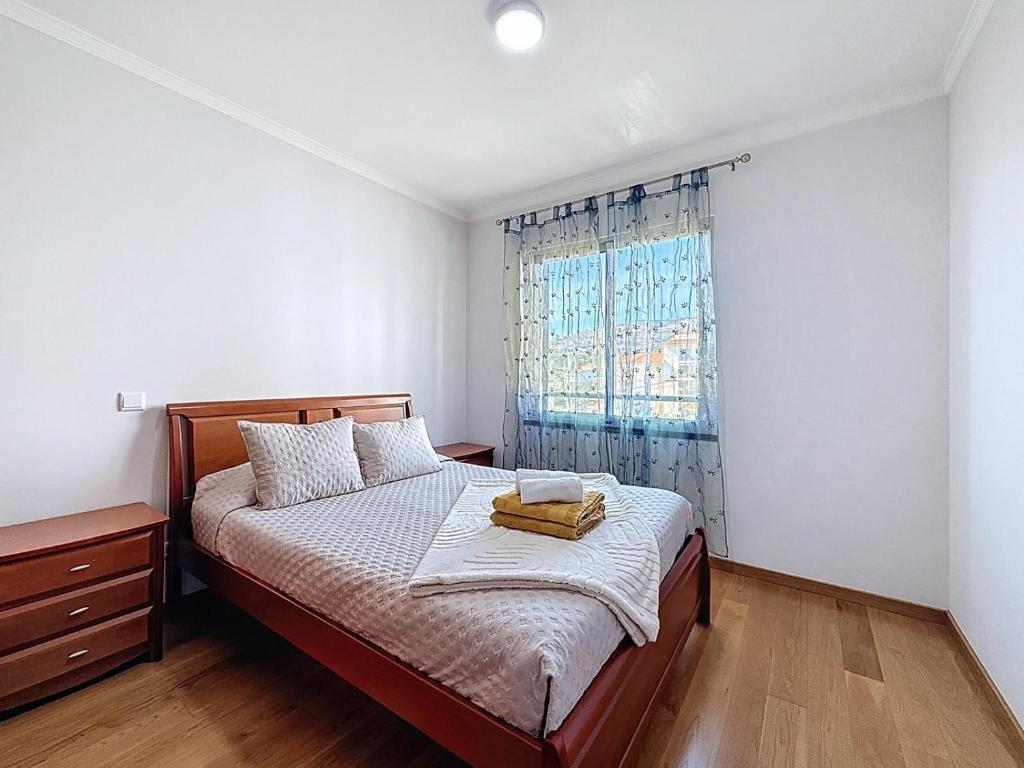a bedroom with a bed and a window at Sea Garden in Caniço