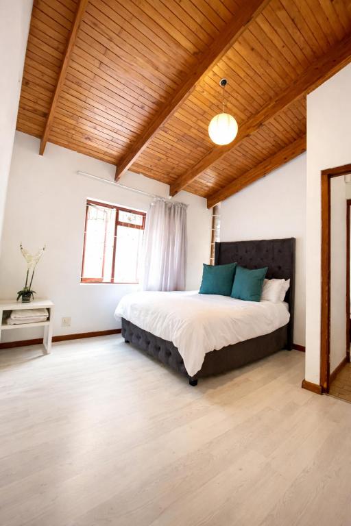 a bedroom with a large bed and a wooden ceiling at Bo-Kaap Double Room with High Ceiling in Cape Town