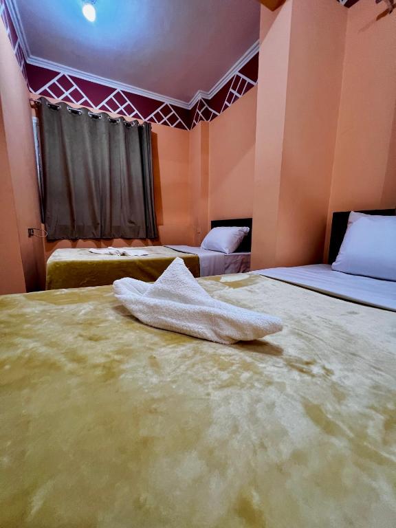 a hotel room with two beds and a towel on the bed at Keylany Hotel Aswan in Aswan