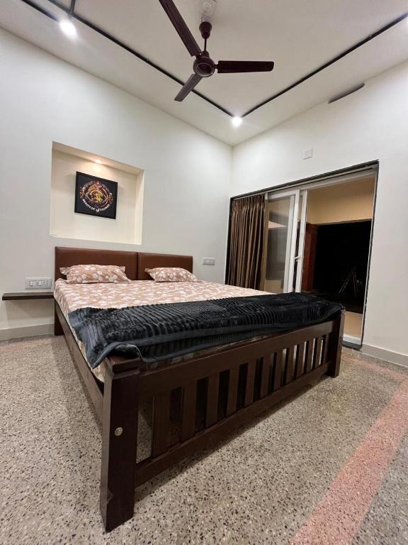 a large bed in a room with a ceiling fan at Vishwageeta 2 in Mangalore