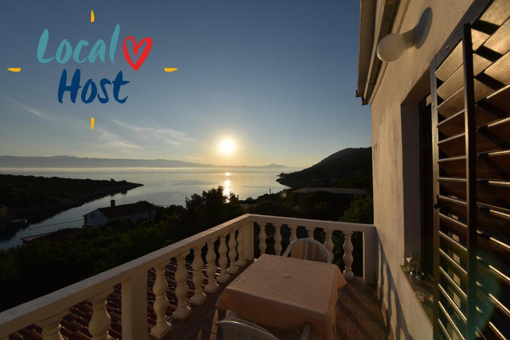 a balcony with a table and a view of the ocean at Apartmani Marko in Gdinj