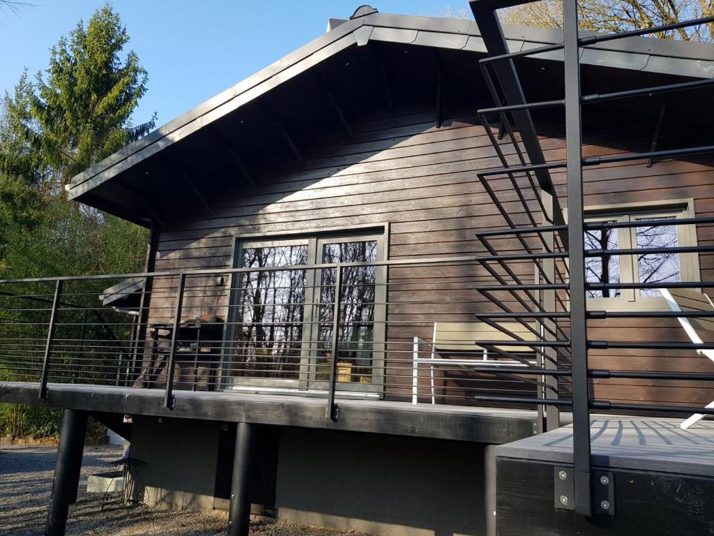 a house with a porch and a deck at Gite Au chalet de Mélines in Melines