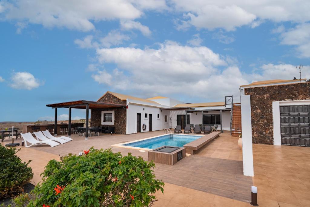 a house with a swimming pool and a patio at Villa Alfalfa in Puerto del Rosario