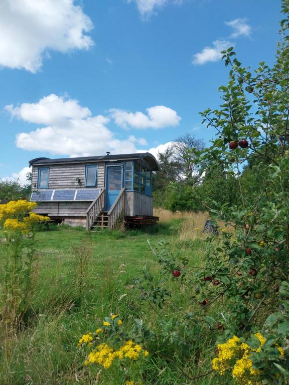 an old house sitting in a field of grass at EcoPod Holidays in Alton