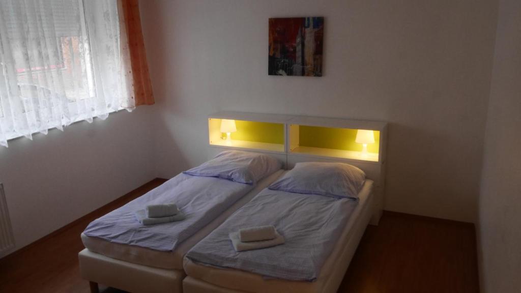 ein kleines Schlafzimmer mit 2 Betten mit Beleuchtung in der Unterkunft Appartements Katharina in Bremerhaven