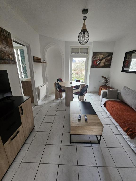 a living room with a couch and a table at F2 avec jardin in Nemours