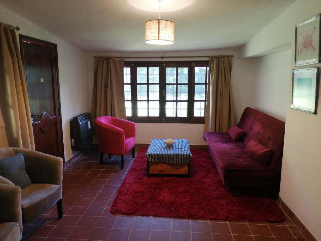 a living room with a purple couch and two chairs at Casa Canela in La Cumbre
