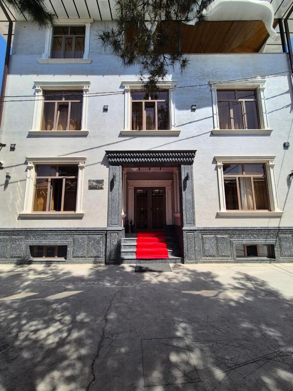 a building with a red rug in front of a door at YASMIN in Samarkand
