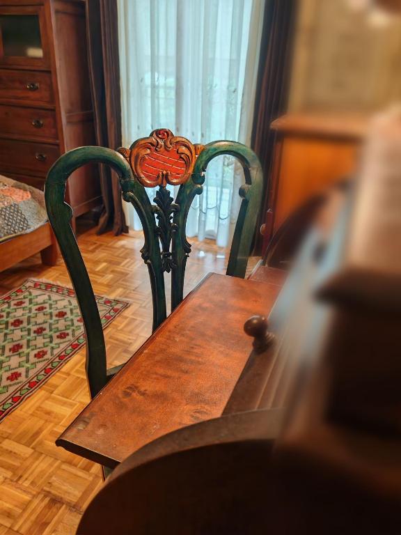 a wooden table and chair in a room at Retro private room in common apartment in Athens