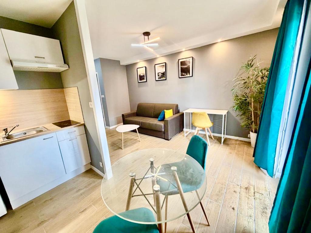 a living room with a table and a couch at Le Genev Altitude - Studio Lumineux - Vue Montagne in Collonges-sous-Salève