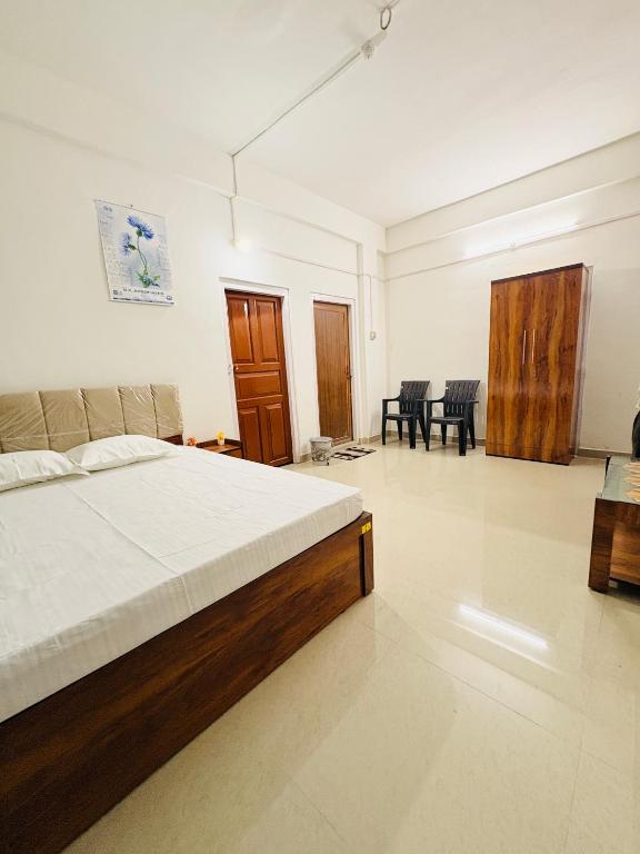 a bedroom with a bed and a living room at Kalm Homestay in Dispur