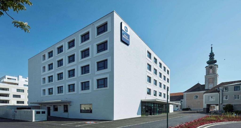 a white building with a clock on the side of it at Best Western Hotel Tulln in Tulln
