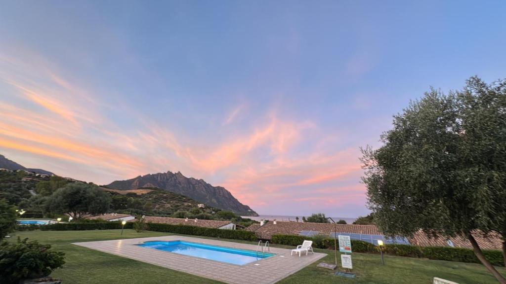 a swimming pool in a yard with a sunset at Villino Giò - Residence Abba Urci in Tertenìa